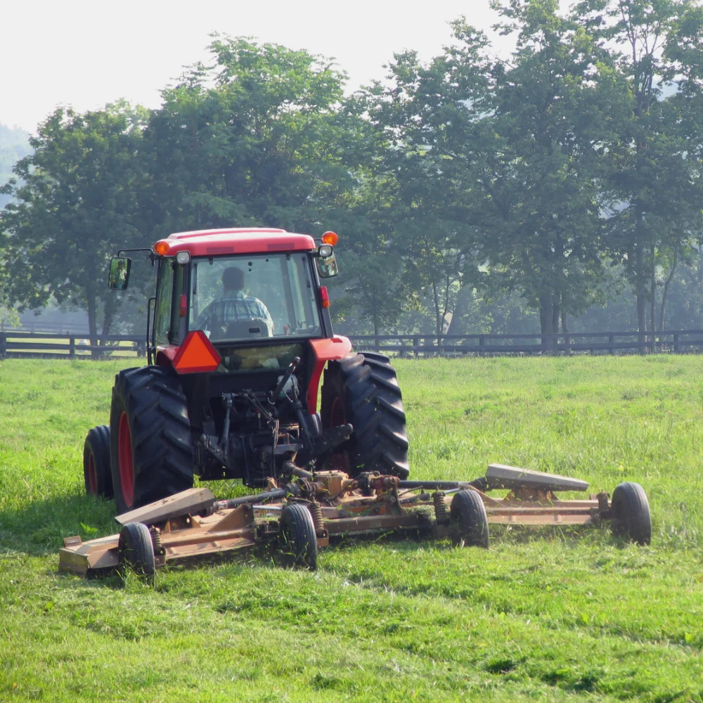 Tractor slashing grass in a large paddock